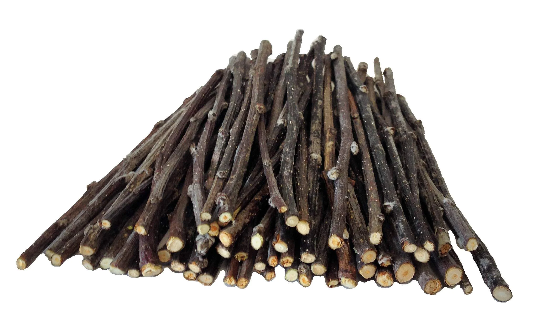 A handful of plain apple wood chew sticks laid on a clean fleece liner next to a hay pile